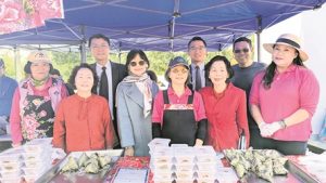 僑領們與客家會志工在客家粽子攤位前合影（攝影：林達）