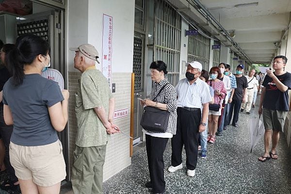 2025年7月26日，台北選民在投票站排隊等候投下同不同意罷免的選票。（I-HWA CHENG/AFP via Getty Images）