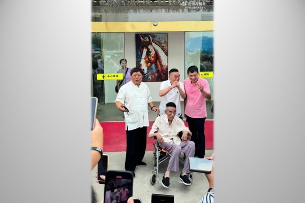 7月9日的天气非常热，杨少华仍被儿子推出来出席剪彩活动。（微博撷图）