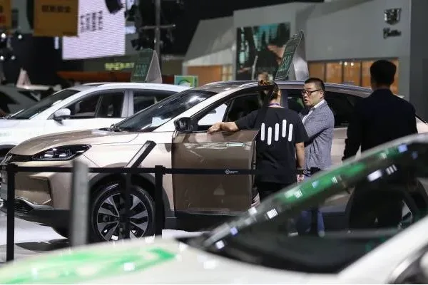 威馬汽車的一名工作人員（左）於2019年6月8日在遼寧省瀋陽市舉行的第 18 屆瀋陽國際汽車工業博覽會上與一名參觀者交談。（STR/AFP via Getty Images）