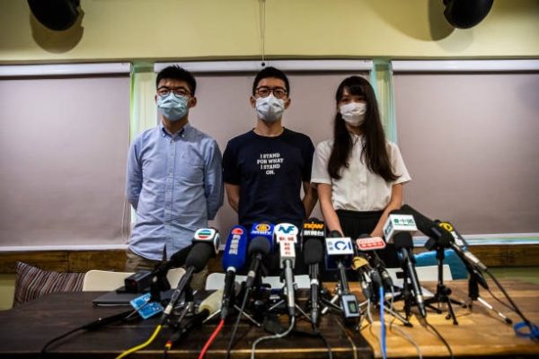 香港眾志成員黃之鋒（左）、羅冠聰（中）與周庭（右），於2020年5月30日在香港舉行記者會。（ISAAC LAWRENCE/AFP via Getty Images）