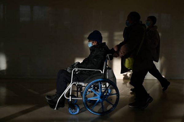 2025年1月10日，在北京一家醫院的走廊上，一名坐輪椅的長者被推著前進。（WANG ZHAO/AFP via Getty Images）
