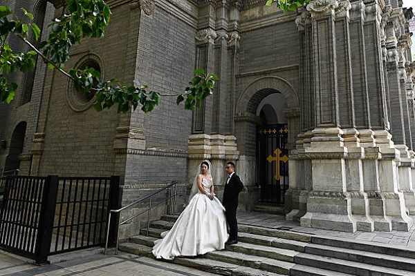 一對新人在2025年4月26日於北京的東堂（聖若瑟堂）拍攝婚紗照。（PEDRO PARDO/AFP via Getty Images）