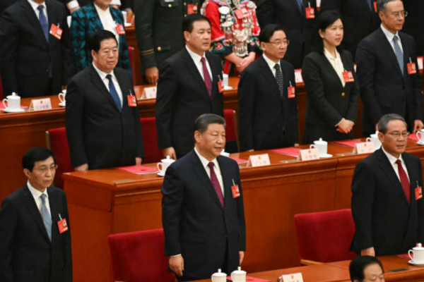 2025年3月11日，中国人民政治协商会议主席王沪宁、中国国家主席习近平和国务院总理李强在北京人民大会堂举行的全国人民代表大会闭幕式上共同奏唱国歌。(Photo by GREG BAKER / AFP) (Photo by GREG BAKER/AFP via Getty Images)