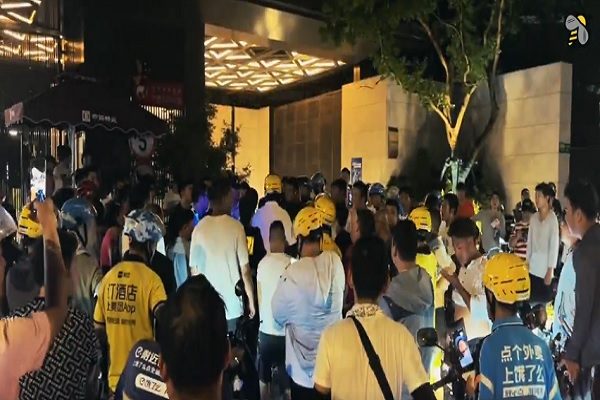 上海200多名外賣員抗議小區「徒步送餐」新規，圍警車迫使警察放人。（「昨天」X帳戶視頻擷圖）