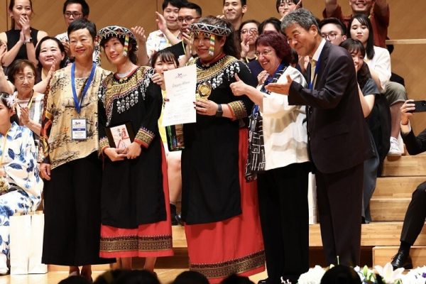 來自高雄的尼布恩合唱團，7月27日以95.9的高分奪得第7屆東京國際合唱大賽民謠組金牌。圖為兩名代表接受評審頒獎。（尼布恩合唱團提供／中央社）
