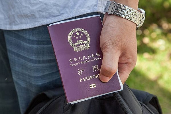 一名中國公民2014年5月16日在柬埔寨的巴維邊境檢查站手持蓋有入境柬埔寨印章的中國護照。（Omar Havana/Getty Images）