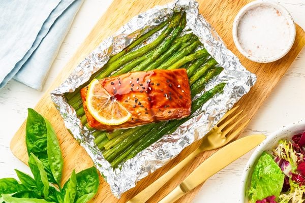 Foil pack dinner with red fish. Fillet of salmon with asparagus. Oven-baked hot dinner, keto paleo diet