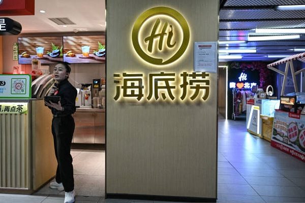 北京一家购物中心内的海底捞火锅店，一名女服务生正在等候顾客。（JADE GAO/AFP via Getty Images）