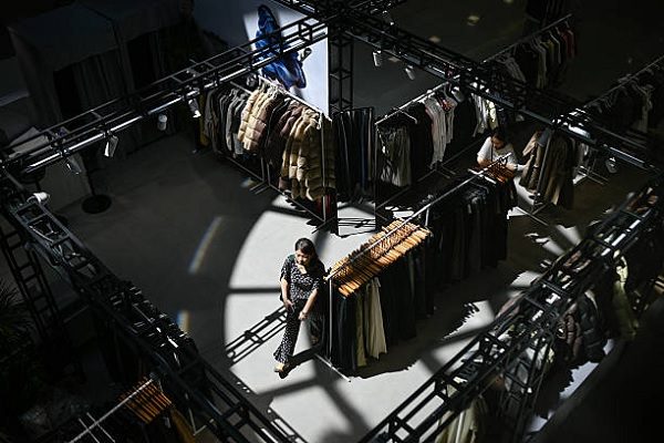 一名女子在北京某商業區的購物中心內一家服裝店裡。（WANG ZHAO/AFP via Getty Images）