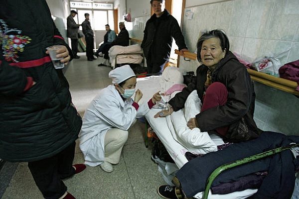安徽省立醫院的護士在醫院擁擠的走廊上為病人做醫療處置。資料圖片。（PETER PARKS/AFP via Getty Images）