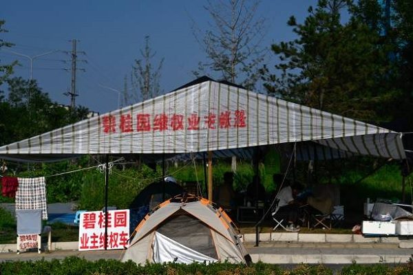 碧桂園的巨額債務引發破產危機時，有民眾2023年8月15日在北京一處碧桂園建案旁抗議。（PEDRO PARDO/AFP via Getty Images）