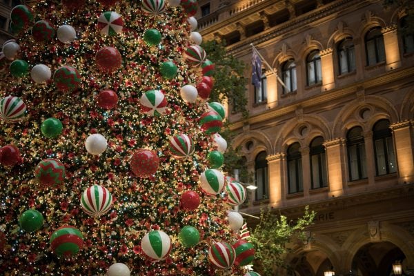 Festive christmas tree decorations baubles green red white historic old sandstone tower building celebration lights dark night
