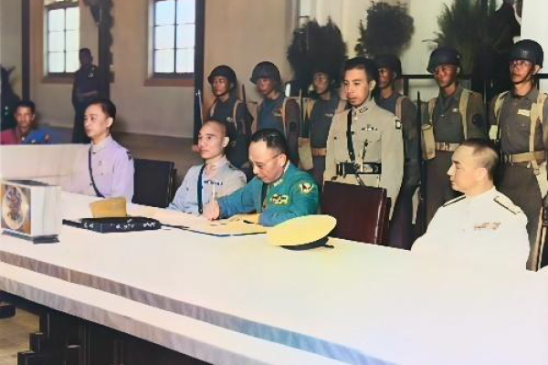 中国战区中国陆军总司令何应钦作为同盟国代表在日军投降书上签字，1945年9月9日，中华民国南京市。 （公有领域）